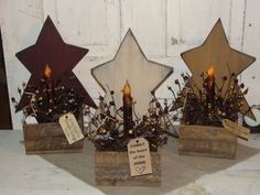 three small wooden stars with candles in them