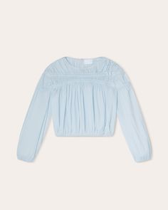 A cropped, voluminous top, the CIEL is offered in Air, a delicate pale blue colourway that's new for Spring. It is decorated with bands of ruching that encircle the front and back yoke as well as the top sleeves. Crafted in sustainable 100% Pima cotton lawn that has a silky handfeel, it is a lightweight offering that pairs well with the matching JARDIN skirt. Update your rotation of plus size tops with this workwear to weekend style Merlette Ciel Top | Air | Tops | Materials & Care Instructions: ['100% Cotton', 'Machine wash cold', 'Imported'] Light Blue Smocked Back Top For Spring, Spring Cropped Blouse With Elastic Sleeves, Blue Top With Smocked Bodice For Daywear, Spring Cropped Blouse With Gathered Sleeves, Spring Cropped Top With Blouson Sleeves, Spring Cropped Elastic Sleeves Crop Top, Spring Cropped Crop Top With Elastic Sleeves, Chic Blue Tops With Elastic Sleeves, Blue Cropped Top With Smocked Bodice