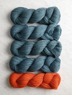 three skeins of yarn sitting next to each other on a white counter top