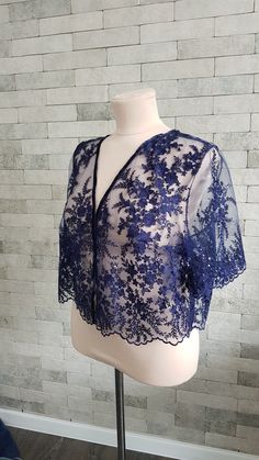 Beautiful and exquisite navy blue lace wedding topper - a truly elegant and unique adding to your bridal gown.  For more wedding tops and boleros, please access https://www.etsy.com/shop/LidiasBoutiqueDesign?ref=seller-platform-mcnav§ion_id=23157300.  For more wedding dresses, please access https://www.etsy.com/shop/LidiasBoutiqueDesign?ref=seller-platform-mcnav§ion_id=23157290.  For more wedding skirts, please access https://www.etsy.com/shop/LidiasBoutiqueDesign?ref=seller-platform-mcnav§ion_id=23168823.  We also recommend our hair bridal accessories https://www.etsy.com/shop/LidiasBoutiqueDesign?ref=seller-platform-mcnav§ion_id=23486819 and our wedding sashes and belts https://www.etsy.com/shop/LidiasBoutiqueDesign?ref=seller-platform-mcnav§ion_id=23425051. For more flower girls dresses Wedding Skirts, Wedding Tops, Bridesmaid Tops, Lace Bolero, Wedding Skirt, Sequin Wedding, Wedding Cape, Blue Sparkle, Sparkle Wedding