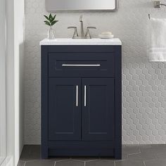 a bathroom vanity with a mirror above it and a towel rack on the wall next to it