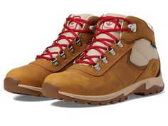 a pair of brown hiking boots with red laces on the outstretches