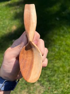 a person holding a wooden spoon in their hand