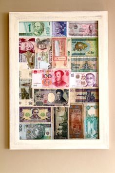 a white frame filled with lots of different types of money on top of a wall