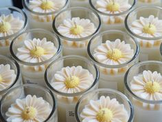 many candles with white and yellow flowers in them