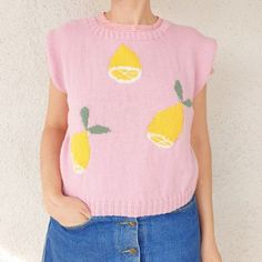 a woman wearing a pink sweater with lemons on it