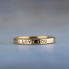 Show her how you feel with this sweet little gold ring.  "I LOVE YOU" is inscribed on this outside of the solid 14k gold ring. It has a smooth finish for a lovely shine.  This ring is ready to ship in a size 5.  If you need a different size, I am happy to make a ring exactly to your specifications. You can find the made to order version of this ring here https://www.etsy.com/listing/99515676.  High quality 1 mm stamps were used to stamp the tiny but readable words on the ring. To see how small the letters are, take a look at a penny. The words "In God we Trust" are the same size. -------------------- About the ring - Handmade from 14k yellow gold. - 2 mm wide (5/64 of an inch) wide - Smooth shiny finish - Inscription outside: I LOVE YOU -------------------- The ring will arrive gift wrappe I Love You Ring, Paper Ring, A Penny, In God We Trust, 14k Gold Ring, Ring Handmade, Ring Box, Handmade Ring, Gold Ring