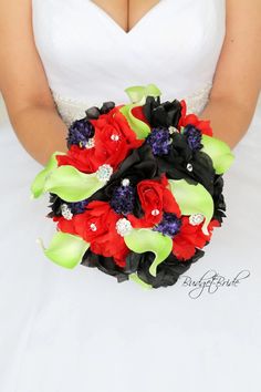 the bride is holding her red and green bouquet