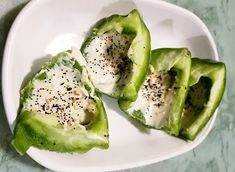 three pieces of avocado on a plate with black pepper sprinkles