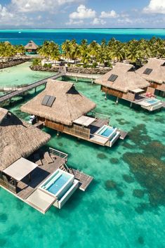 an aerial view of some huts in the water