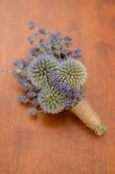 a bunch of purple flowers sitting on top of a wooden table