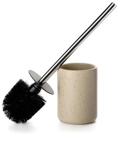 a cup with a brush in it sitting next to a toothbrush holder on a white background