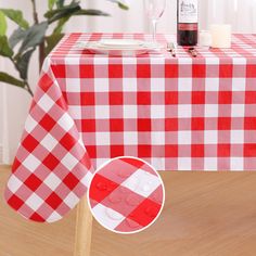 a red and white checkered table cloth with wine bottle on it, next to a wooden chair