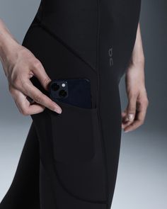 a person is holding their cell phone in the pocket of her leggings and showing it to the camera