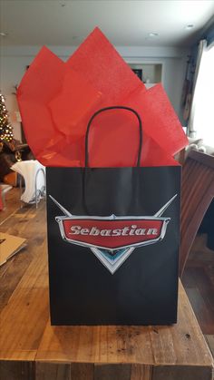 a black shopping bag sitting on top of a wooden table