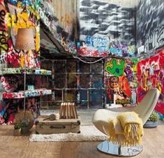 a living room filled with lots of graffiti covered walls and floor to ceiling paintings on the walls