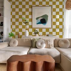 a living room with yellow and white checkered wallpaper on the walls, couches and coffee table