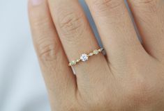 a woman's hand with a three stone diamond ring on her left hand,