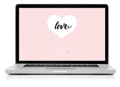 an open laptop computer sitting on top of a white surface with the word love written on it