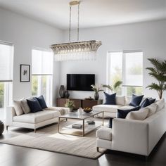 a living room filled with furniture and a chandelier hanging from the ceiling in front of two windows