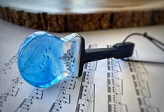 a blue glass ring sitting on top of sheet music