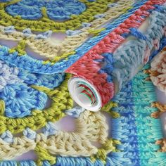 a crocheted table cloth is laying on top of another piece of knitted material