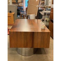 an office desk with a chair in the background and other furniture on display behind it