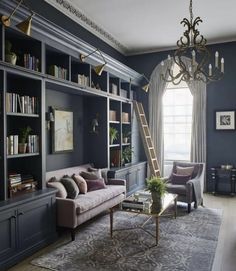 a living room with bookshelves, couches and a ladder in the corner