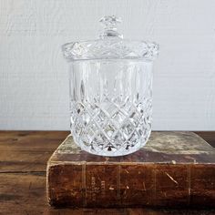 a glass jar sitting on top of an old book