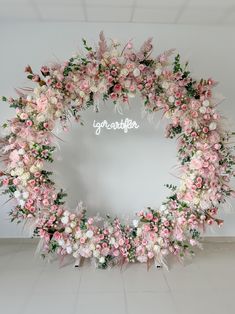 a pink and white floral wreath with the word congratulations written on it