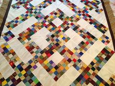 a quilt is laying on the floor with many different colors