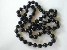 a bunch of black beads on a white surface