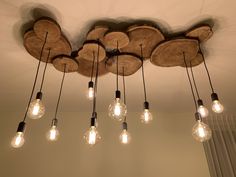 a chandelier made out of wood with light bulbs hanging from the ceiling above it