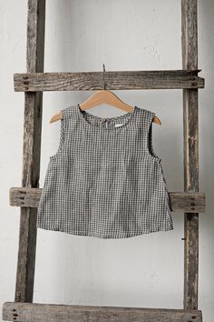 Sleeveless unisex shirt with a coconut button in the back is made of 100% soft medium weight linen. The shirt is suitable for both girls and boys.  Details: - Choose size and embroidery in the drop down menu - Colour: Grey gingham - Composition: 100% Oeko-Tex certified linen - Coconut button in the back - Medium weight linen - Unisex  - Relaxed silhouette - Linen care: machine wash gentle; tumble dry low, ironing optional - The price is for one shirt, other pictured items are not included Sleeveless Gingham Blouse For Spring, Spring Gingham Sleeveless Blouse, Spring Sleeveless Gingham Blouse, Sleeveless Plaid Blouse For Summer, Sleeveless Gingham Blouse For Summer, Sleeveless Gingham Tops For Summer, Summer Sleeveless Gingham Blouse, Sleeveless Plaid Top For Summer, Sleeveless Gingham Cotton Top