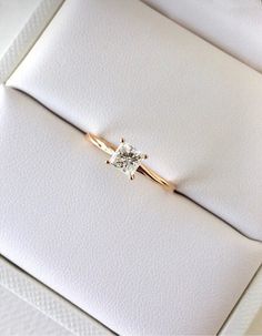 a diamond ring sitting on top of a white envelope