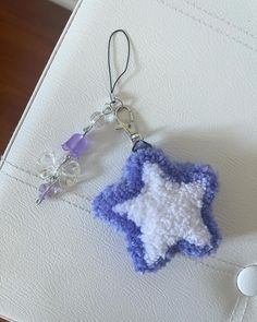 a crocheted keychain with a blue and white star hanging from it