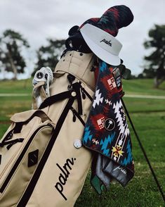 a golf bag and hat sitting in the grass