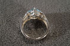 I am offering you this vintage sterling silver Art Deco style band ring with a gorgeous prong set trillion triangle shaped, genuine blue topaz stone. There is a regal influence in the design here, very nice! There is fabulous design setting. It measures app. 3/4 inch, by app. 1/4 inch. It has color saturation and intensity that is endless, as seen in the provided pictures. What an eye catcher! It has the classic highly desired solid setting that is very thick and substantial, giving this ring al Anniversary Topaz Ring With Accent Stones, Trillion Cut, Anniversary Trillion Cut Topaz Ring With Accent Stones, Formal Trillion Cut Topaz Ring In Fine Jewelry Style, Formal Trillion Cut Topaz Fine Jewelry Ring, Trillion Cut Topaz Jewelry For Anniversary, Fine Jewelry Topaz Ring With Trillion Cut, Fine Jewelry Topaz Ring With Trillion Cut Gemstone, Fine Jewelry Trillion Cut Topaz Ring, Trillion Cut Topaz Ring With Accent Stones