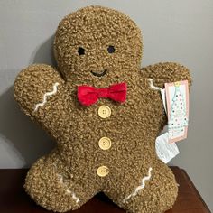 a large teddy bear with a red bow tie on it's head and chest