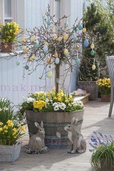 several potted plants with easter eggs in them on the ground near a table and chairs