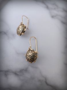 Inspired by the ubiquitous metallic discs punctuating NYC streets, our domed 14k Gold Floral Medallions are a homage to the beauty found in utilitarian objects. Crafted from 14k sheet, domed and patterned using traditional stamping tools finished with a gear edge expertly crafted from 14k wire Black enamel is applied to great effect highlight the floral patterns stamped into the gold. Dangling for our gently curved 14k Ear wires, these light domes will dangle just below the lobe, approximately 7 Vintage 14k Gold Engraved Earrings, Gold Etched Drop Earrings, Yellow Gold Medallion Brass Earrings, Silver Round Byzantine Earrings, Engraved Yellow Gold Brass Earrings, Antique Engraved Round Earrings, Elegant Etched Round Earrings, Antique Round Engraved Earrings, Sterling Silver Etched Gold Earrings