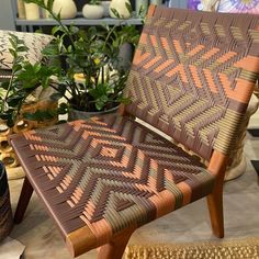 a brown chair sitting on top of a wooden floor next to a potted plant