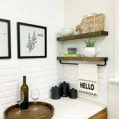 a bathroom with two framed pictures on the wall and a wine glass in the sink