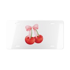 two cherries with pink bow on white license plate for car or truck, front view