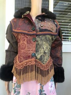 This vintage J Wilde brocade 'Jungle' jacket is a great find for the vintage and wearable art enthusiast. Any bohemian admirer or hippie fashion lover will be thrilled at this fusion of a stunning multicoloured design with fringe accents, faux fur, corded braid, and wool tweed. As well as being a visual feast of mixed media, it's warm and comfortable for the cooler months ahead. The jacket is in pre-owned condition, but its hard to see any signs of wear on this jacket. It's got big shoulders, fu Vintage Brown Patchwork Outerwear, Vintage Multicolor Outerwear With Buttons, Brown Steampunk Outerwear For Winter, Brown Costume Outerwear With Buttons, Brown Steampunk Winter Outerwear, Steampunk Brown Winter Outerwear, Vintage Reworked Winter Outerwear, Vintage Reworked Outerwear For Winter, Vintage Multicolor Outerwear For Festival