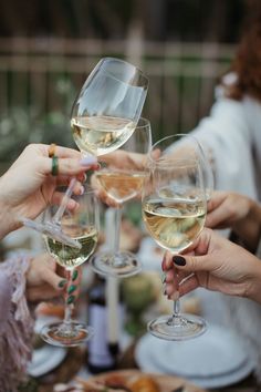 several people are toasting with wine glasses