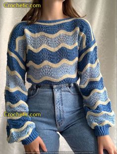 a woman is wearing a blue sweater and jeans