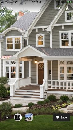 a gray house with white trim on the front porch and steps leading up to it