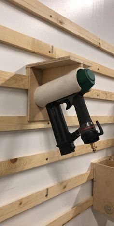 a paint sprayer mounted to the side of a wall with wooden planks behind it