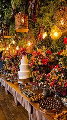 a long table with many different types of food on it and lights hanging from the ceiling